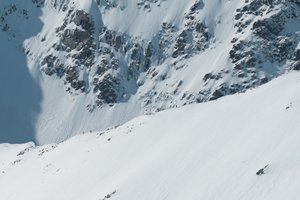 A high zoom photo looking towards a section of the CMD arete on a sunny day. Tiny figures can be seen descending it.