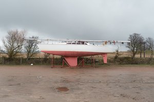 Looking side on to a small boat on stilts out of water.