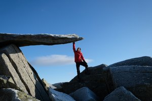 Chris reaches up to a large cantilevered overhanging him.
